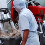 丸又の製造現場で、石臼を使って魚肉を塩摺りする様子