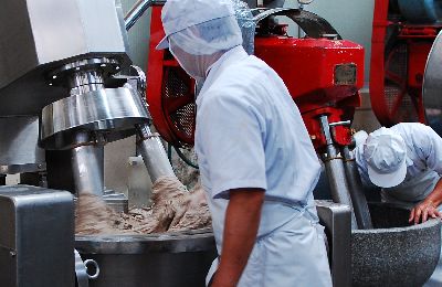 丸又の製造現場で、石臼を使って魚肉を塩摺りする様子