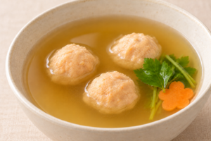 つみれ団子を汁物に盛り、青菜とにんじんを添えた調理例